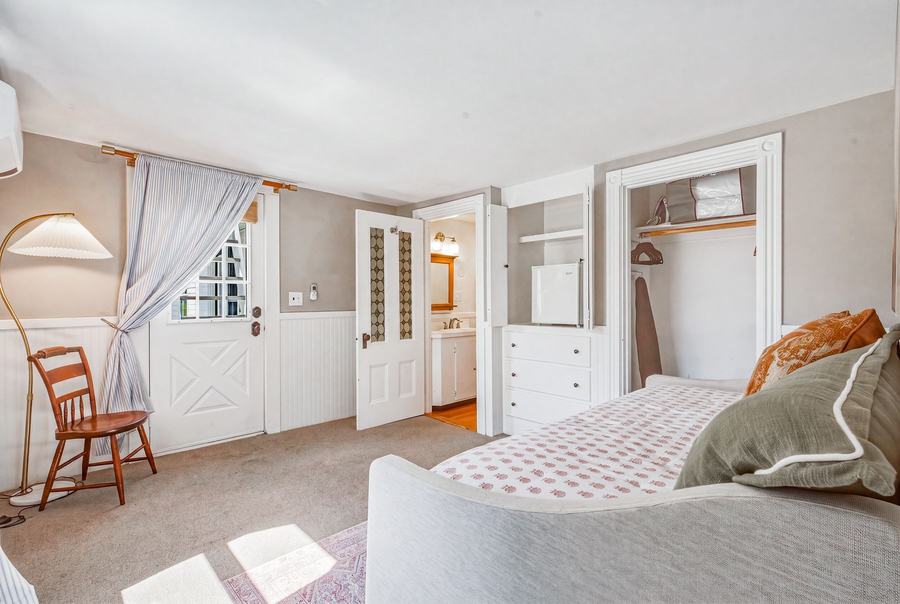 Coastal guest room sitting area with built-in shelves and storage